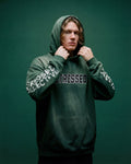 Person wearing a green hoodie with text on a solid background